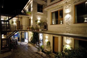 Un edificio de varios pisos con escaleras, balcones e iluminación exterior.