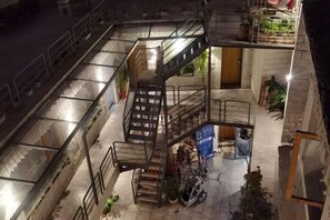 A multi-level courtyard with a central staircase, outdoor seating area, and a bicycle. - Fengma Feiyang Hostel (Lhasa)
