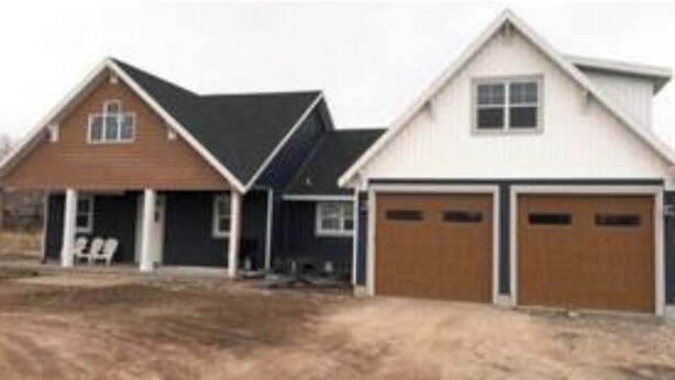 A residential property with two detached houses, each with a garage. The houses have pitched roofs and are surrounded by a dirt driveway. - North Shore Oasis - 5 minutes from the lake! (St. Charles)