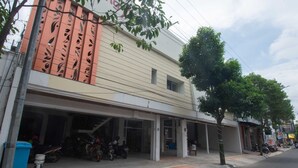 Un edificio con varias fachadas comerciales, entre ellas una tienda de reparación de motocicletas.