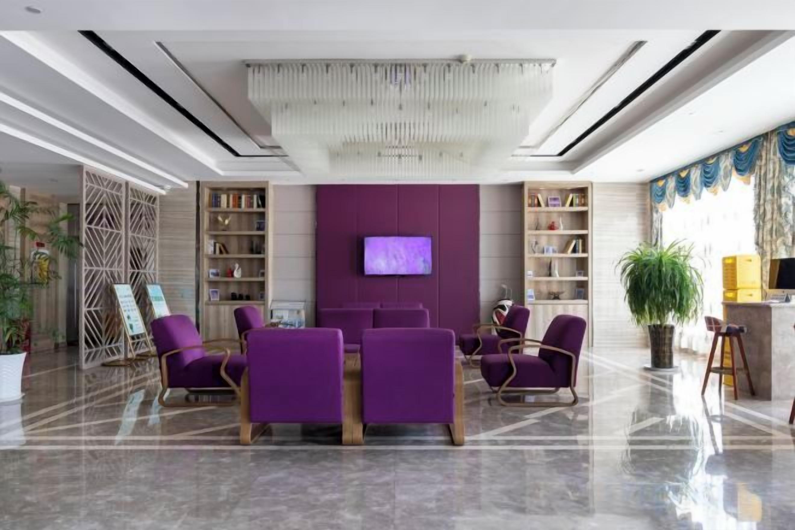 A lobby with a central seating area, a television, and bookshelves.