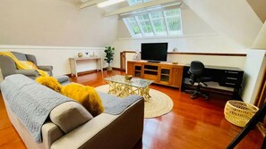 Ein Wohnzimmer mit einer Couch, einem Couchtisch, einem Fernseher und einem Holzschrank.