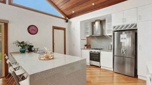 Eine moderne Küche mit Kochinsel, Edelstahlgeräten und Holzboden.