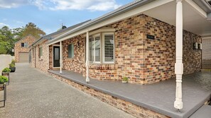 Ein Backsteinhaus mit überdachter Veranda und Garage.