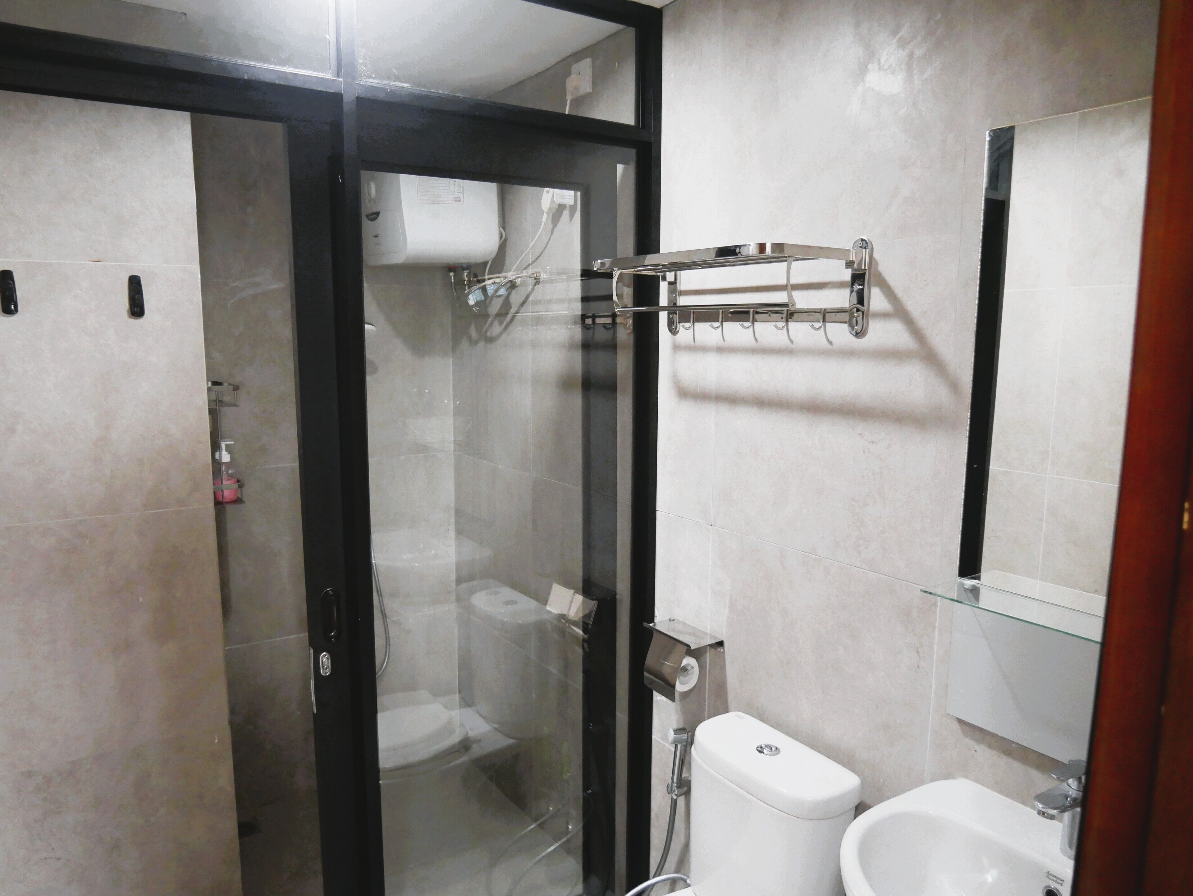 A modern bathroom with a glass-enclosed shower, a toilet, and a sink.