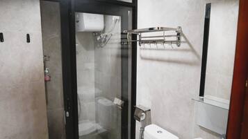 A modern bathroom with a glass-enclosed shower, a toilet, and a sink.