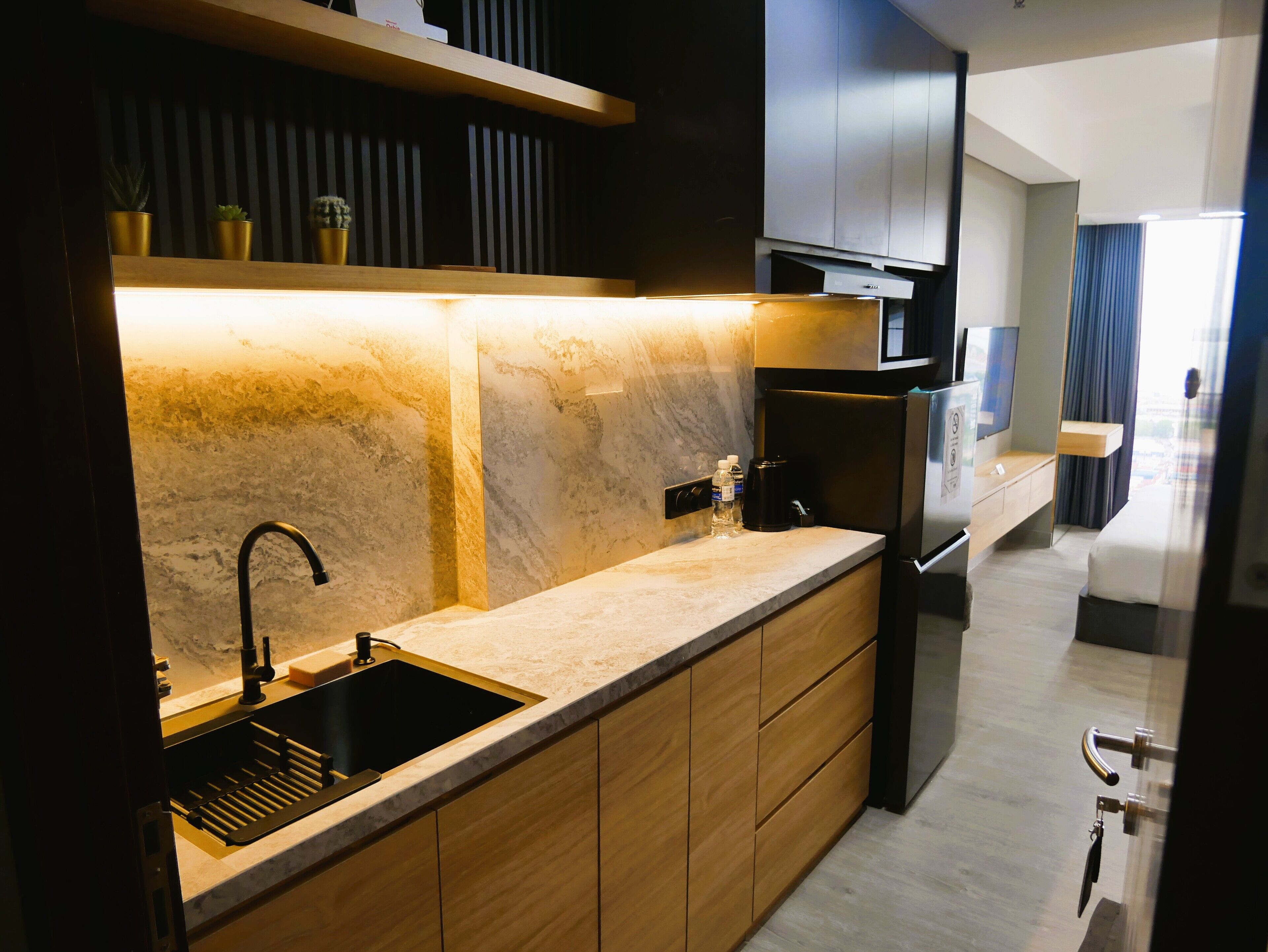 Una cocina moderna con encimera de mármol, un fregadero y un horno empotrado.