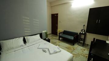 Habitación de hotel con cama, sofá, una mesita y un armario.