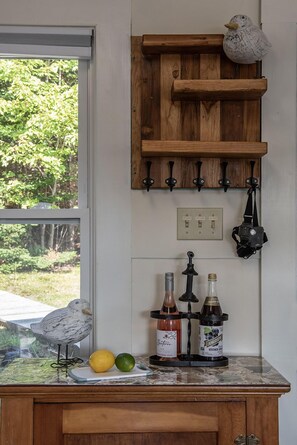 Enjoy a view of lush greenery from the kitchen window, where you can prepare a meal with a cutting board and wine.