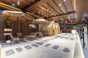 A room with a thatched roof, wooden ceiling, and stone flooring. - Shanxia Hotel (Bome)