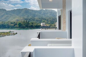 A balcony with a view of a lake and a forested hill. - Water House (Yuchi)