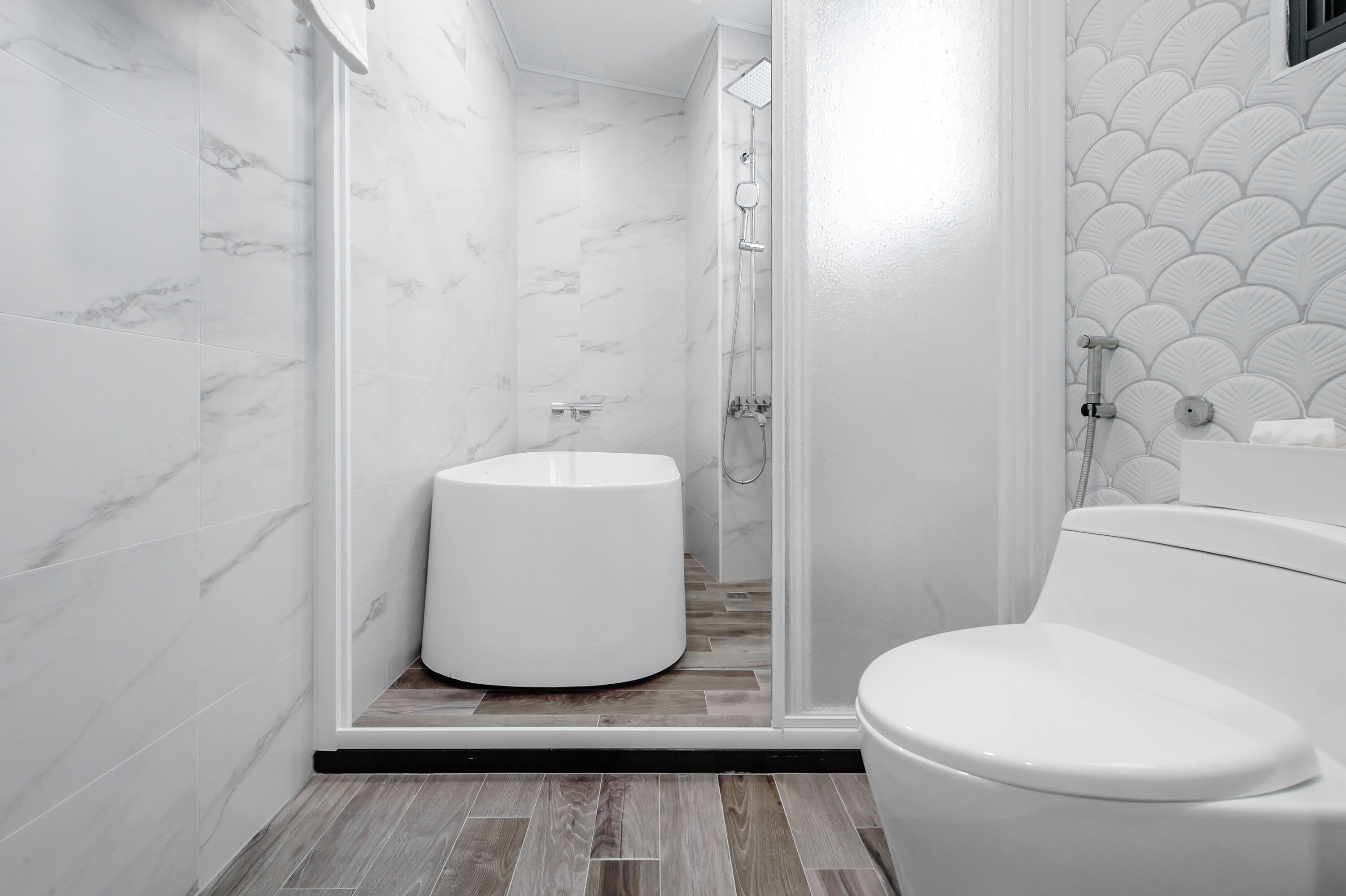Un bagno moderno con il water, una doccia con porta in vetro e un lavandino.