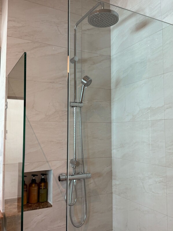 A modern shower with a handheld showerhead and a rain shower head. - Sichon Hideaway (Sichon)