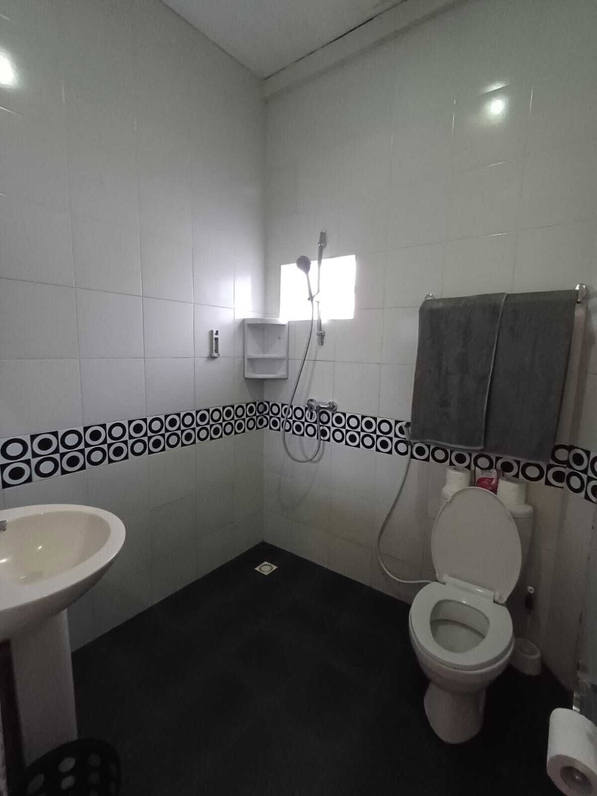 A small bathroom with a toilet, sink, and shower.