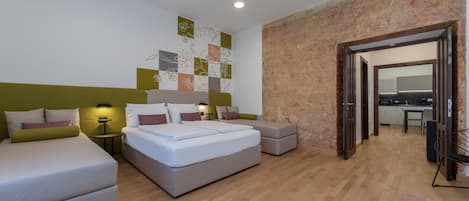 A modern bedroom with a large bed, two bedside tables, and a small seating area.