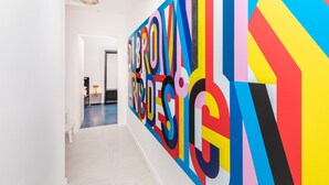 A hallway with a large, colorful wall art installation. - Cap rooms (Dubrovnik)