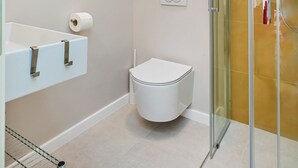 A modern bathroom with a glass shower enclosure, a white toilet, and a towel rack. - Cap rooms (Dubrovnik)