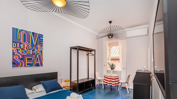 A modern hotel room with a large bed, a desk, and a chair. - Cap rooms (Dubrovnik)