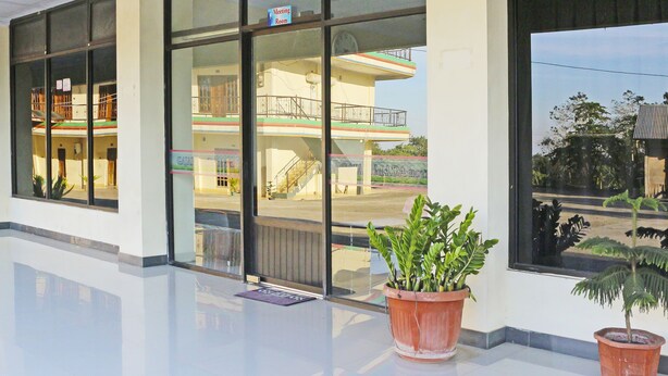 A hotel lobby with large windows, a reception desk, and a potted plant. - Collection O 91517 Hotel Gajah Mada Soe (Soe)