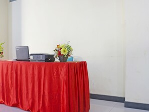 A table with a red tablecloth, a laptop, a printer, and a vase of flowers. - Collection O 91517 Hotel Gajah Mada Soe (Soe)