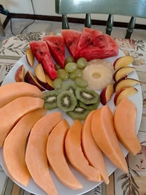 Un plato con una variedad de frutas, como sandía, uvas, kiwi y melocotones.