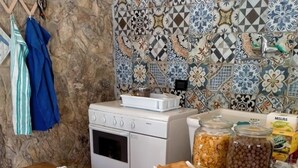 A table with various food items including bread, cheese, and meats, with a tiled backsplash and a stove in the background. - Agriresort Villa Bentivoglio (Piazza Armerina)