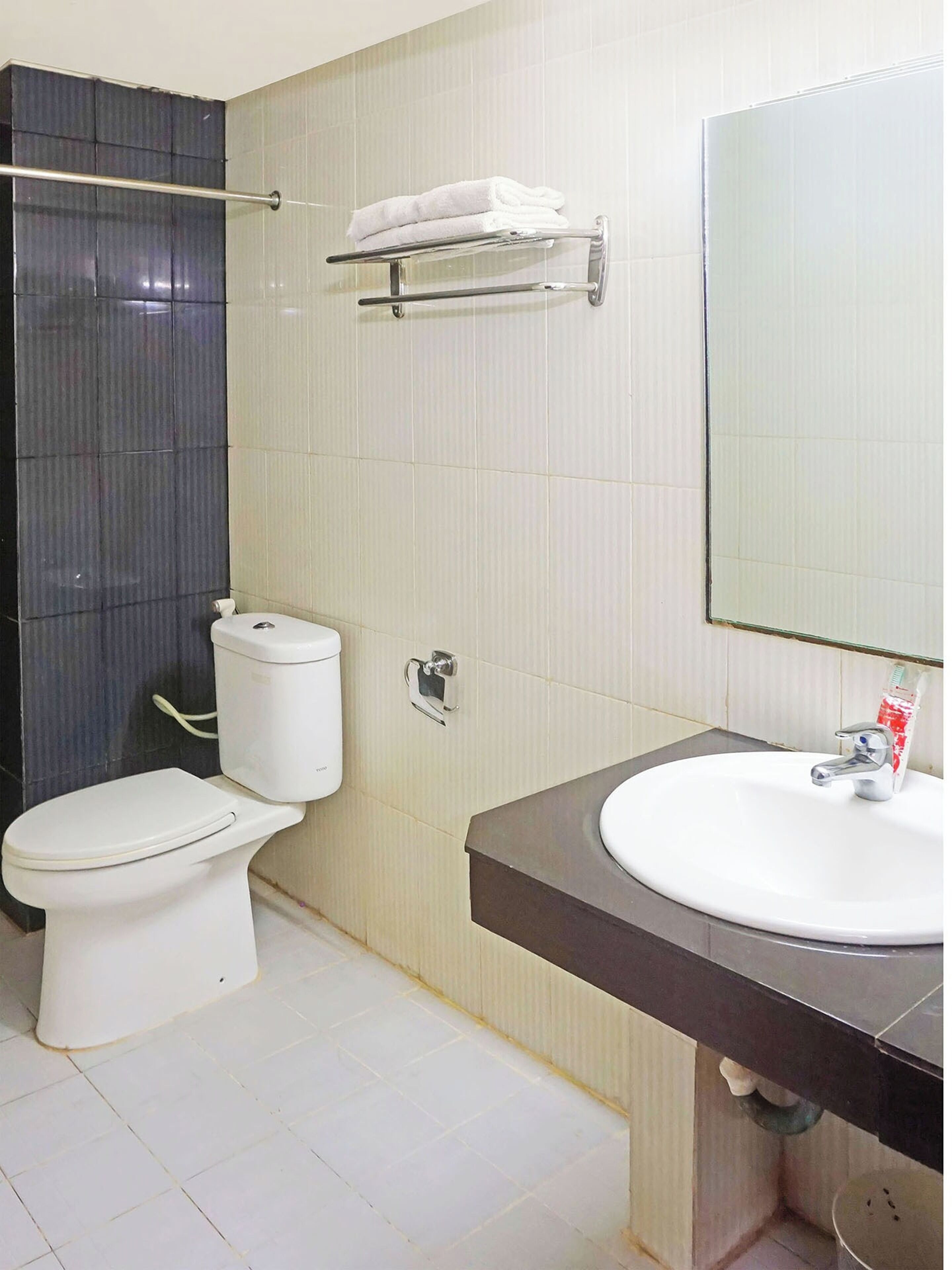 Ein Badezimmer mit Toilette, Waschbecken und Handtuchhalter.