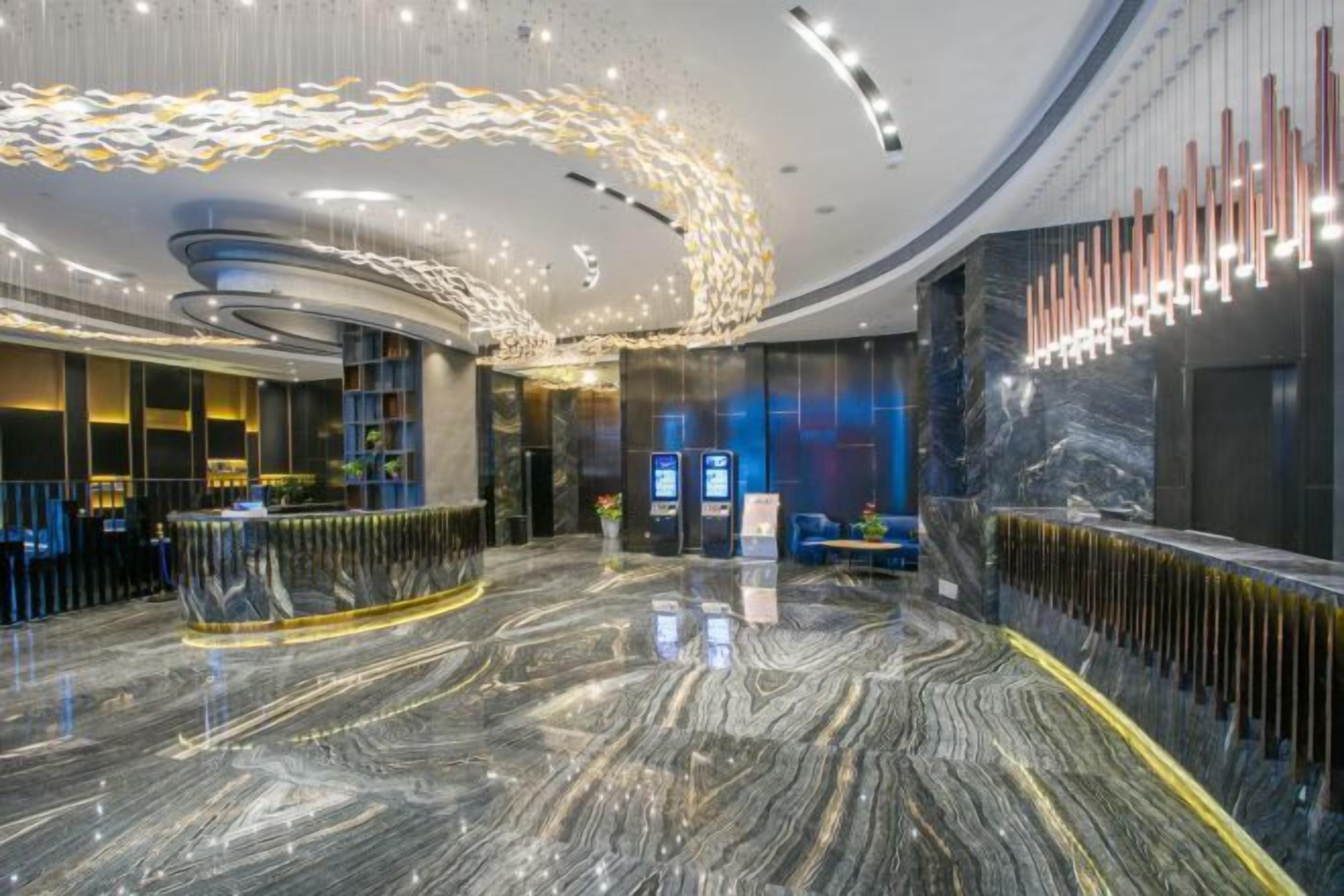 A modern lobby with a marble floor, a reception desk, and a curved ceiling design.