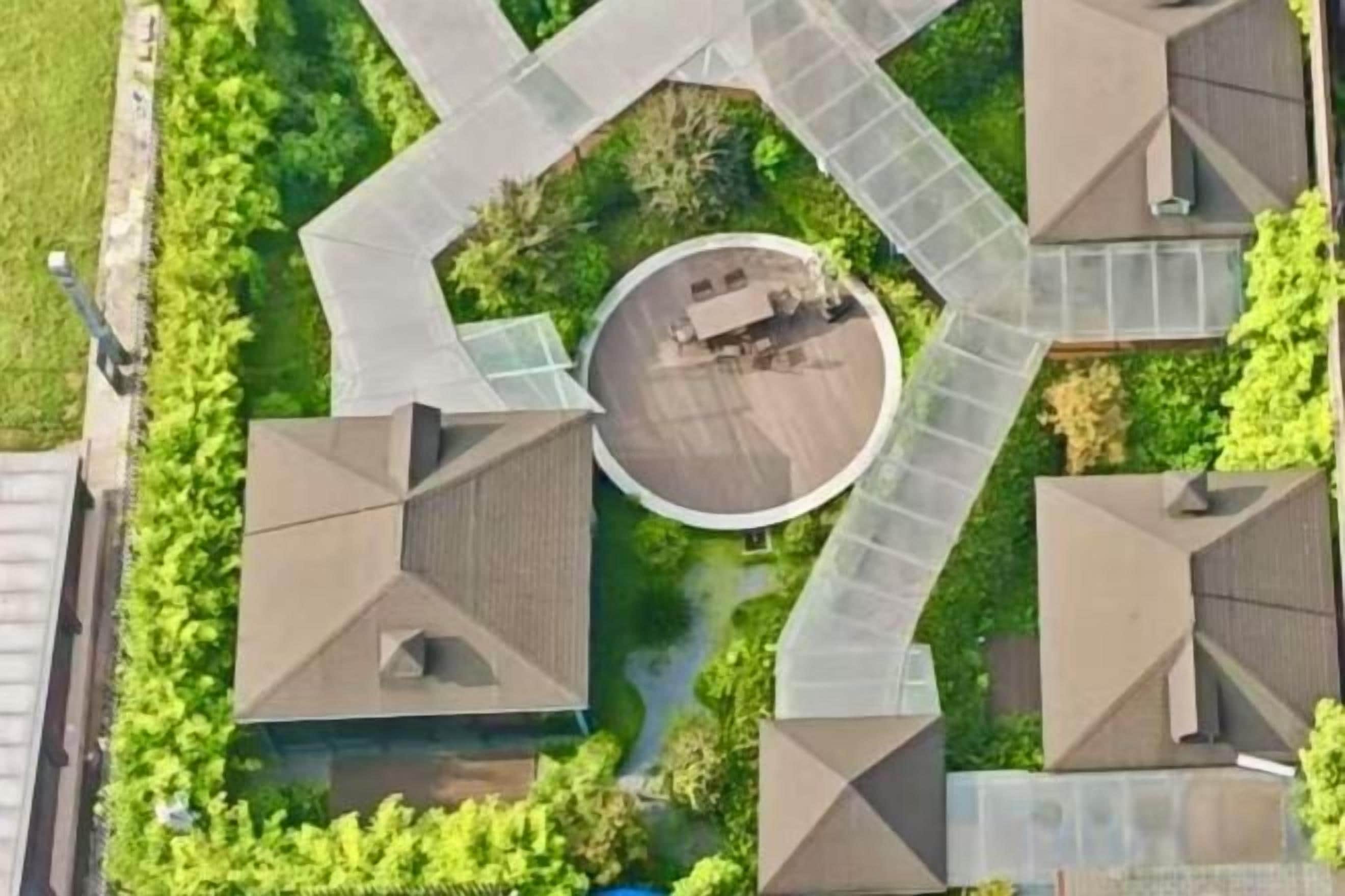 A residential complex with a central courtyard, multiple buildings, and surrounding greenery.