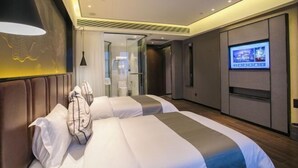 Habitación de hotel con dos camas, televisión y diseño moderno.