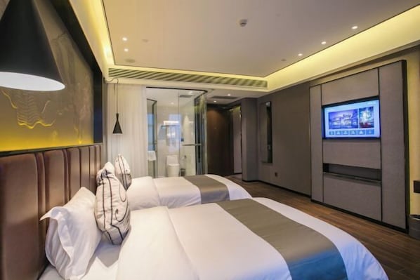 Habitación de hotel con dos camas, televisión y diseño moderno.