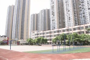A residential building with multiple high-rise apartments, a sports court, and a small park area. - Ruiman International Hotel (Changsha)