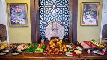 Une table de buffet garnie de divers plats et un mur décoratif orné de motifs géométriques.