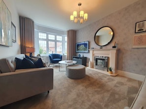 Cozy living room with a comfortable sofa, fireplace, and large windows.