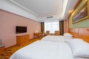 A hotel room with two beds, a TV, a desk, and a chair. - Vienna Hotel (Pingle)