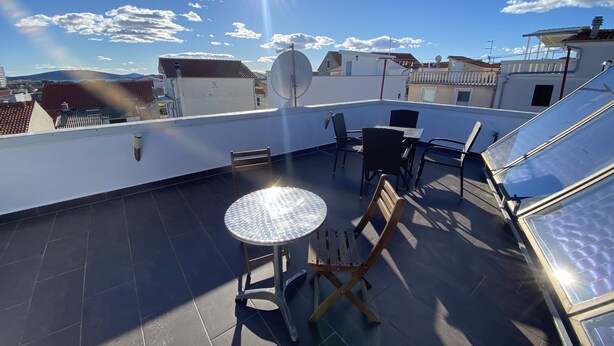 A rooftop terrace with a round table, chairs, and a satellite dish. - Apartment 2,5 rooms in 2nd stock with roof teracce (Vodice)