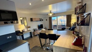 A modern kitchen with a Bosch microwave, a wooden island, and a hexagonal tile floor. - Appartement entre Lac et Montagne chez Justine (SAINT JEAN DE SIXT)
