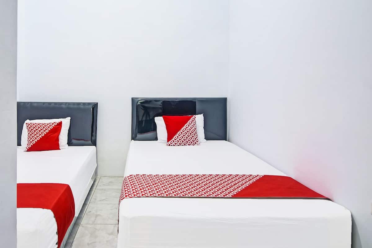 Two single beds with grey headboards and red accents, white bedding, and a tiled floor.