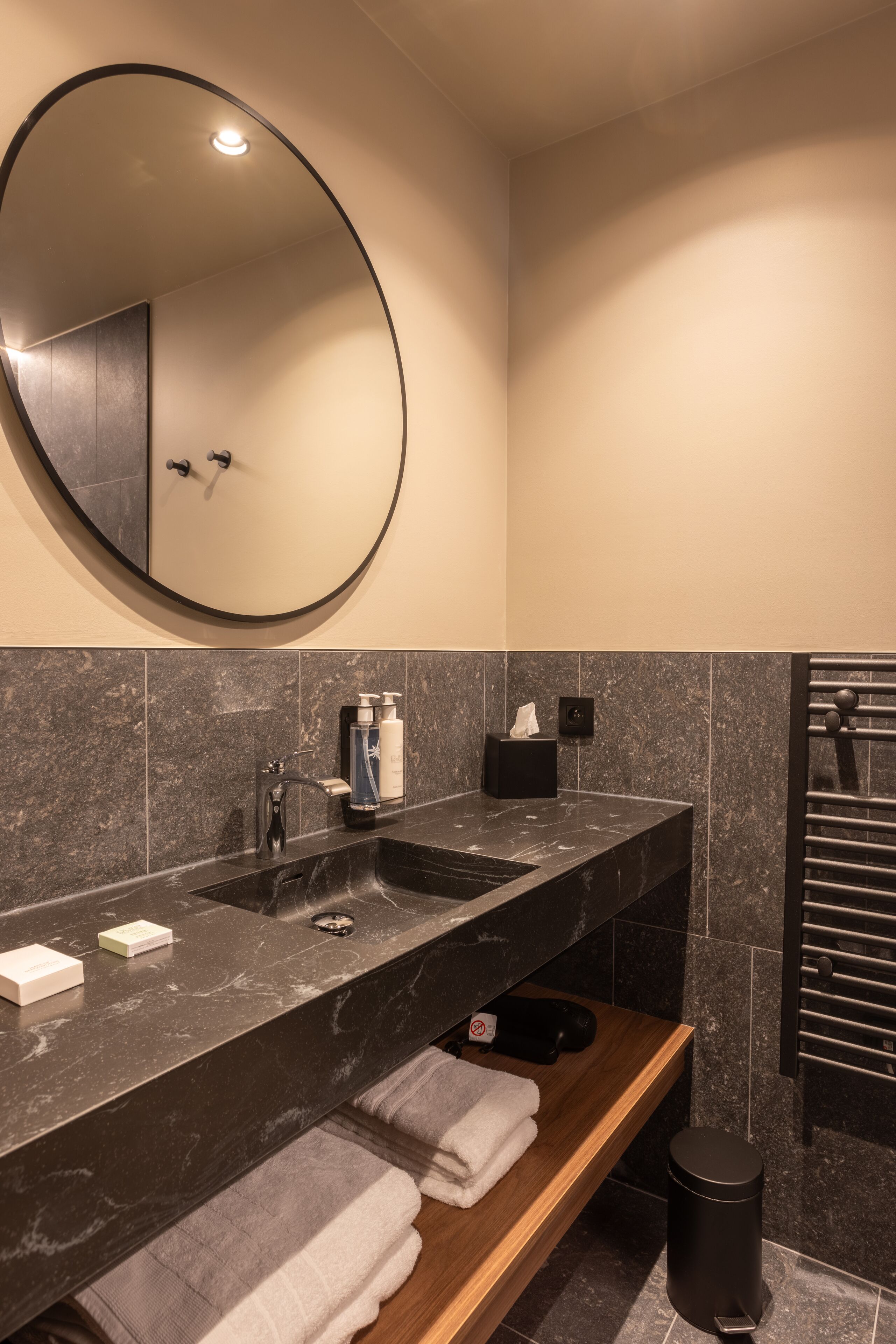 A modern bathroom with a large mirror, dual sinks, and a towel rack.