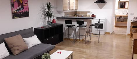A modern apartment with a living room, kitchen, and dining area.