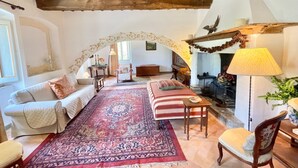 A cozy living room with a high ceiling, wooden beams, a large rug, and a fireplace. - Umbrian Paradise Contains 5 Bedrooms With Private Pool and Stunning Views (Spoleto)