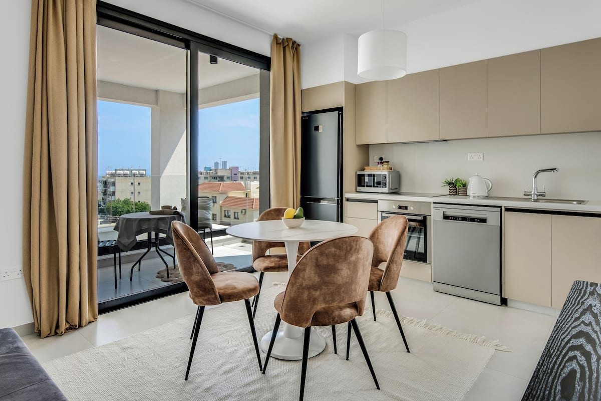 Una cocina moderna con comedor, ventanas amplias y vistas a la ciudad.