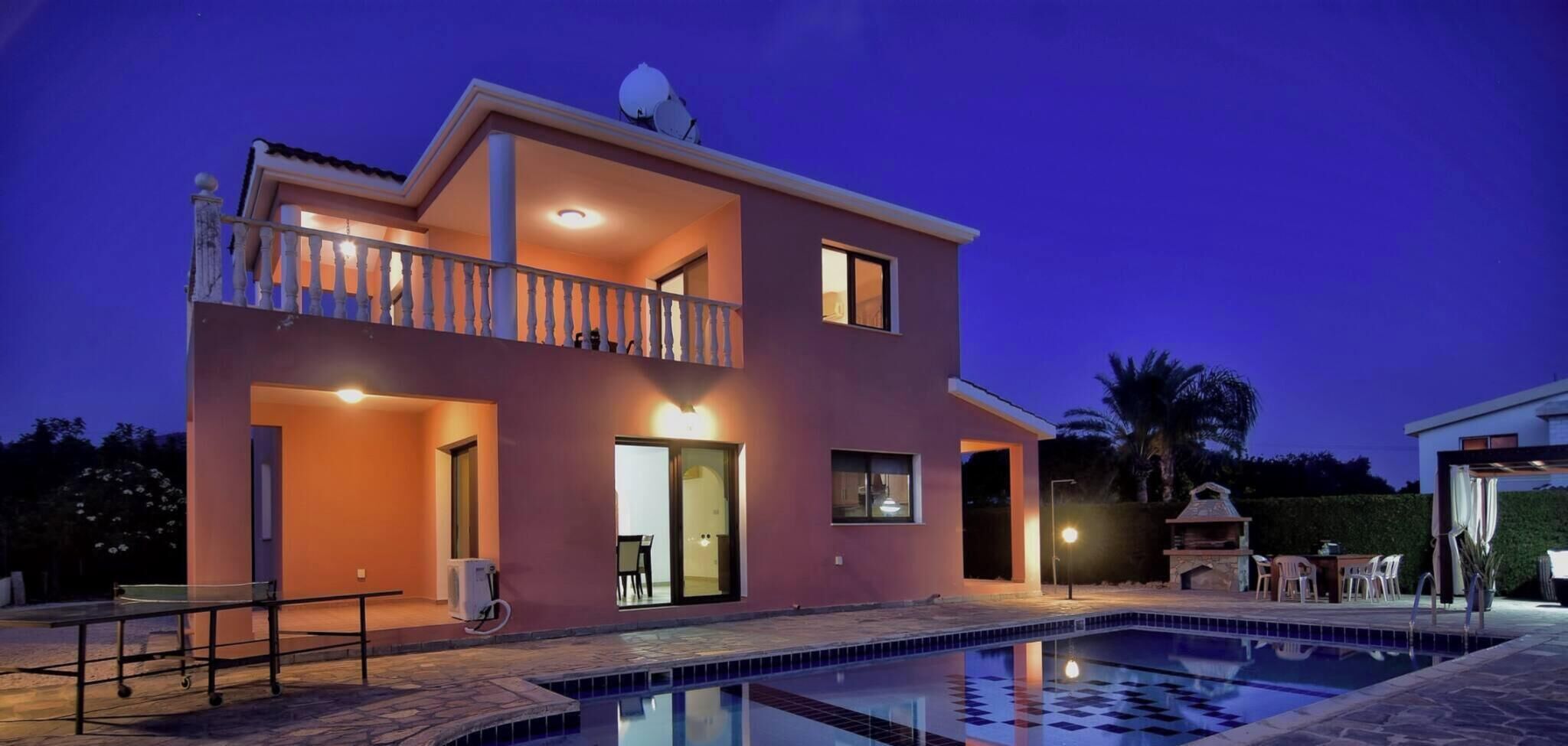 A two-story house with a swimming pool, a balcony, and a satellite dish.