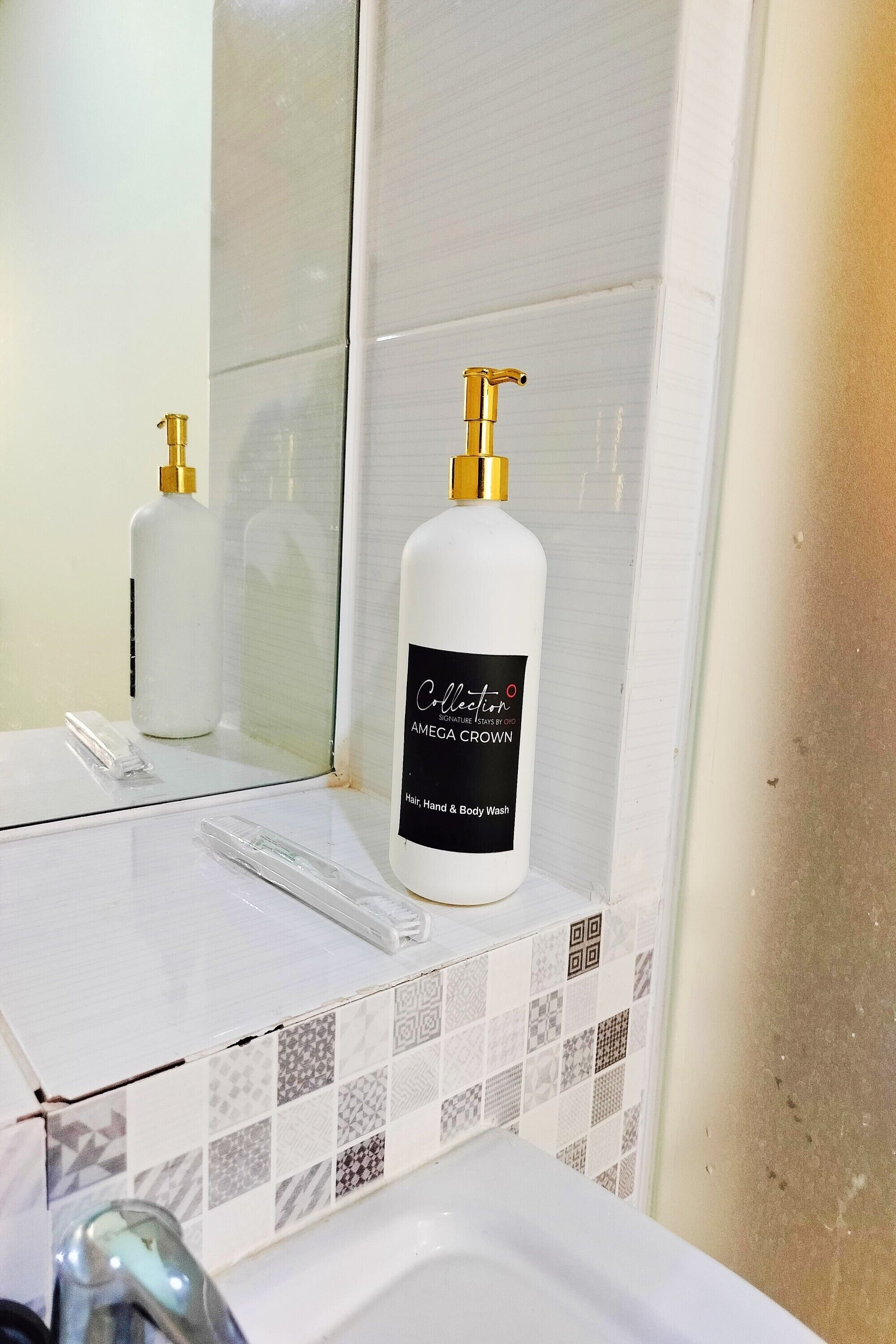 A bathroom with a white sink, a mirror, and a bottle of 'Collection' body wash.