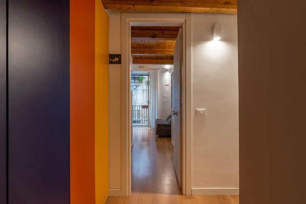 A hallway with a wooden ceiling, a door leading to a room, and a view of a balcony with a railing. - Casa Abbanniata a Ballar by Wonderful Italy (Palermo)