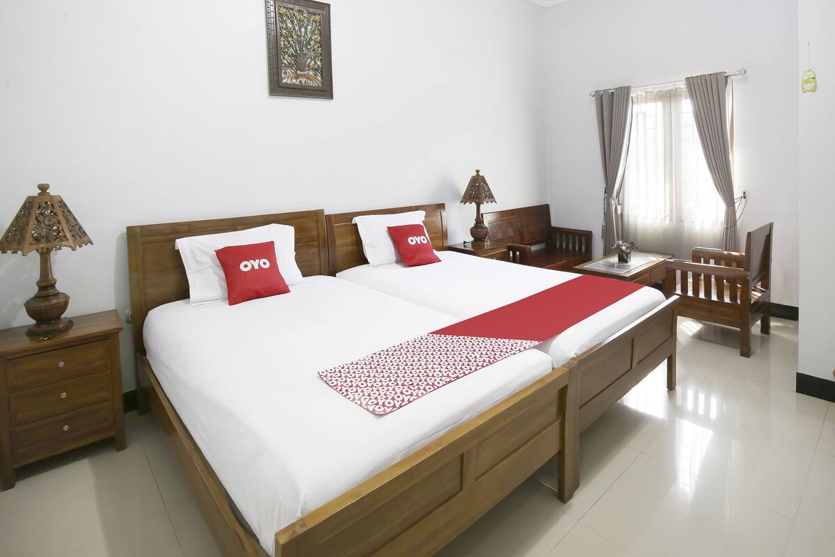 A hotel room with a large bed, two bedside tables, a desk, and a chair.