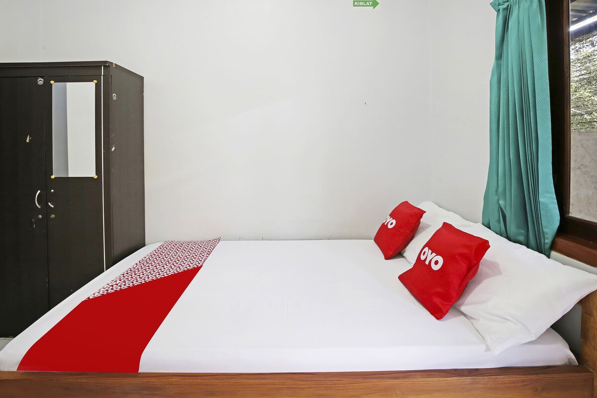 Una habitación de hotel con cama, armario y vistas al exterior.