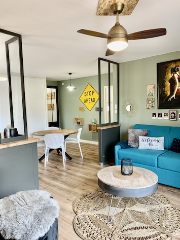 PiÚce principale avec salon, coin repas, et baie vitrée donnant sur la terrasse