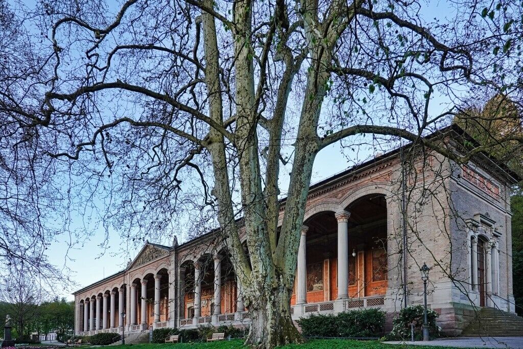A classical building with a symmetrical facade, multiple arches, and a central entrance.