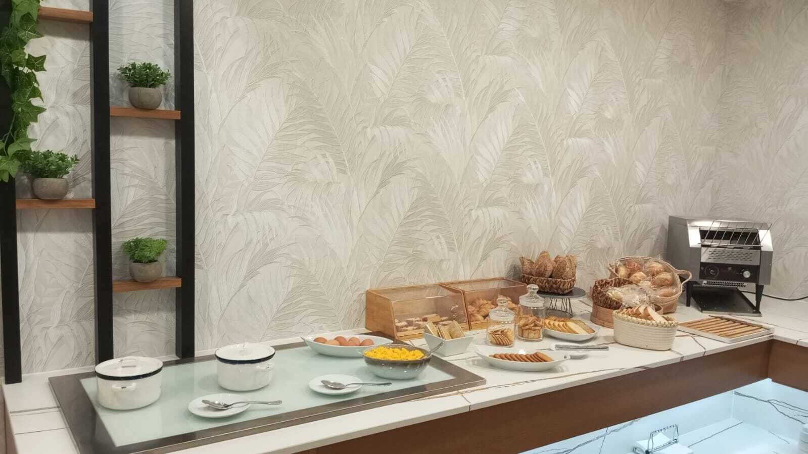 Buffet de l'esmorzar amb diferents aliments i una màquina de cafè.